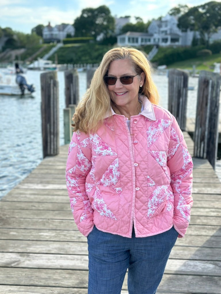 Woman wearing The Chatham Quilt Coat on a Cape Cod harbor dock — peach and pink floral toile patchwork pinwheel coat with corduroy collar, Women’s Medium