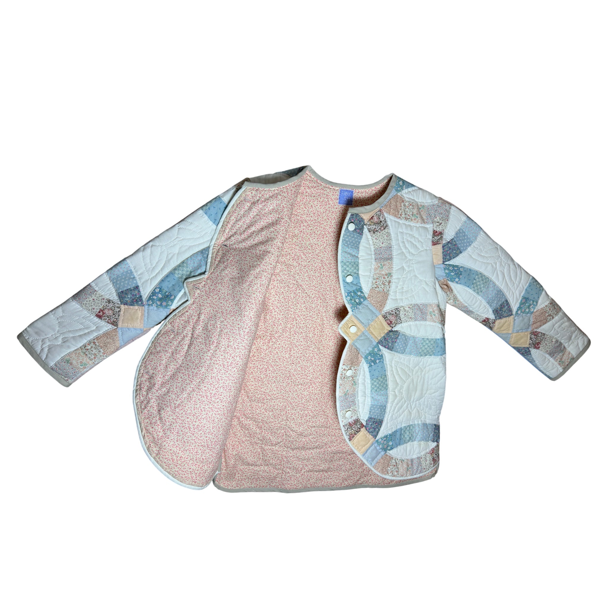 Interior of heirloom quilted coat with 100 percent cotton lining in white peach and pink, handmade jacket detail