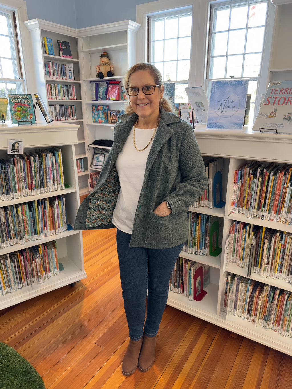 Woman wearing blue Fabric & Soul made jacket in children's library. 