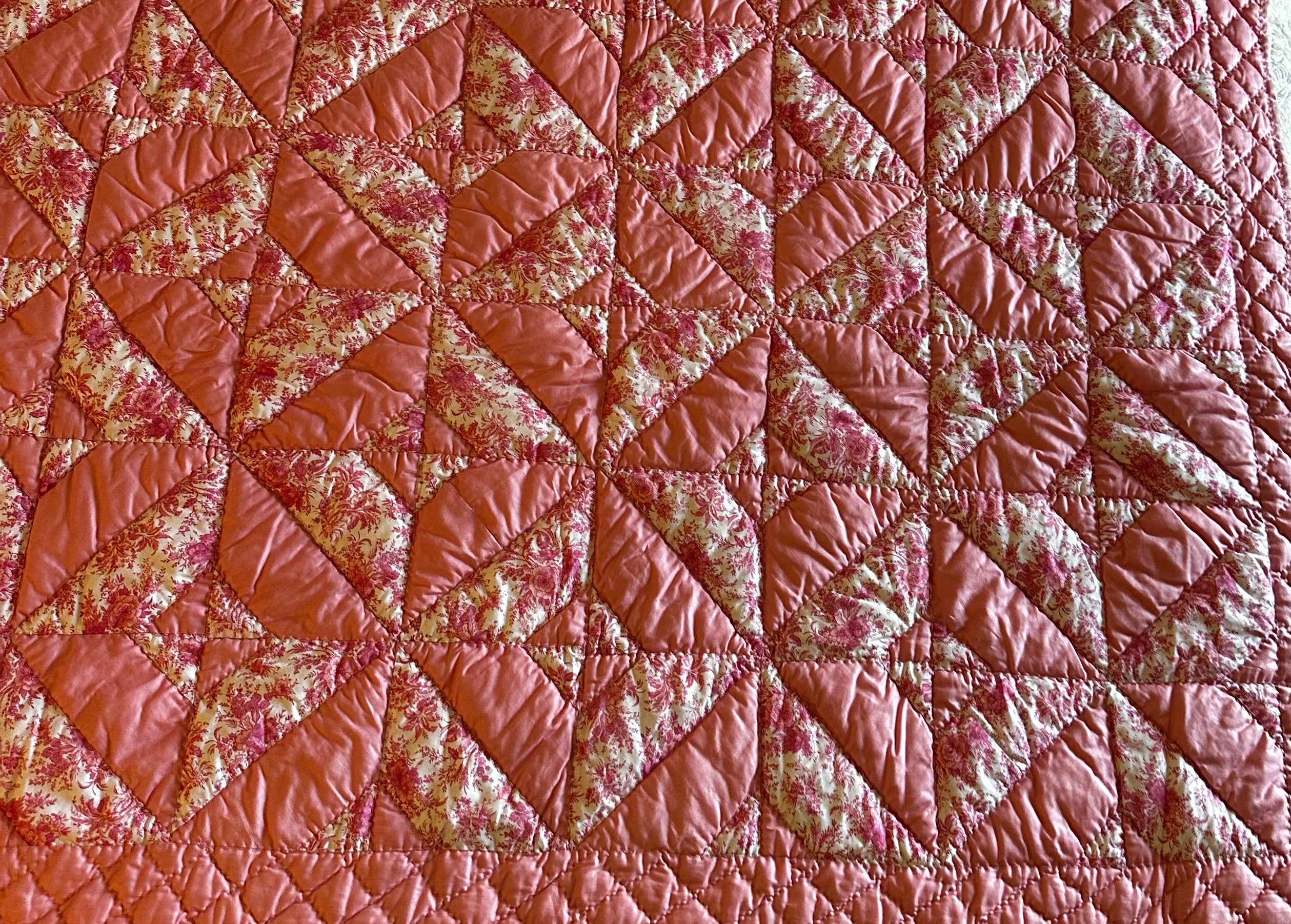 Original Chatham estate sale quilt showing pinwheel star patchwork pattern in dusty rose and pink floral toile — the source textile for the Fabric & Soul Signature Collection coats