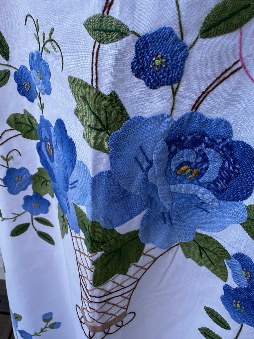 Vintage blue floral basket appliqué close-up on handmade white cotton tunic — one-of-a-kind upcycled slow fashion by Fabric & Soul