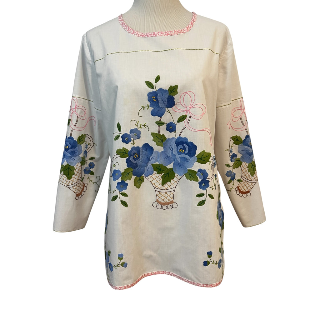 Front view of handmade white cotton tunic with blue floral basket appliqué centered on body — upcycled vintage tablecloth, size Medium, Fabric & Soul