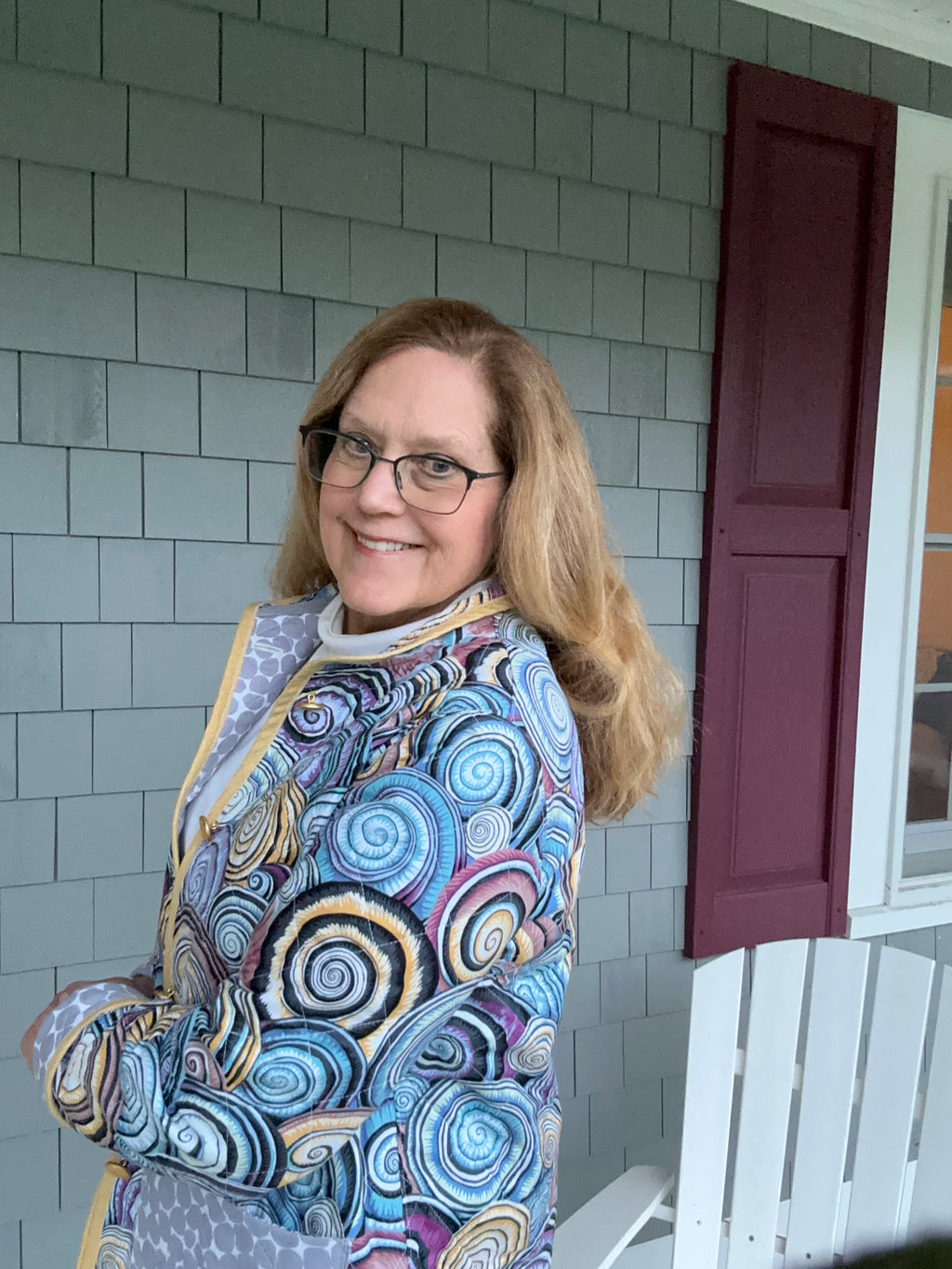 Women's quilted coat side view Kaffe Fassett shell print with vintage brass anchor buttons and golden binding detail