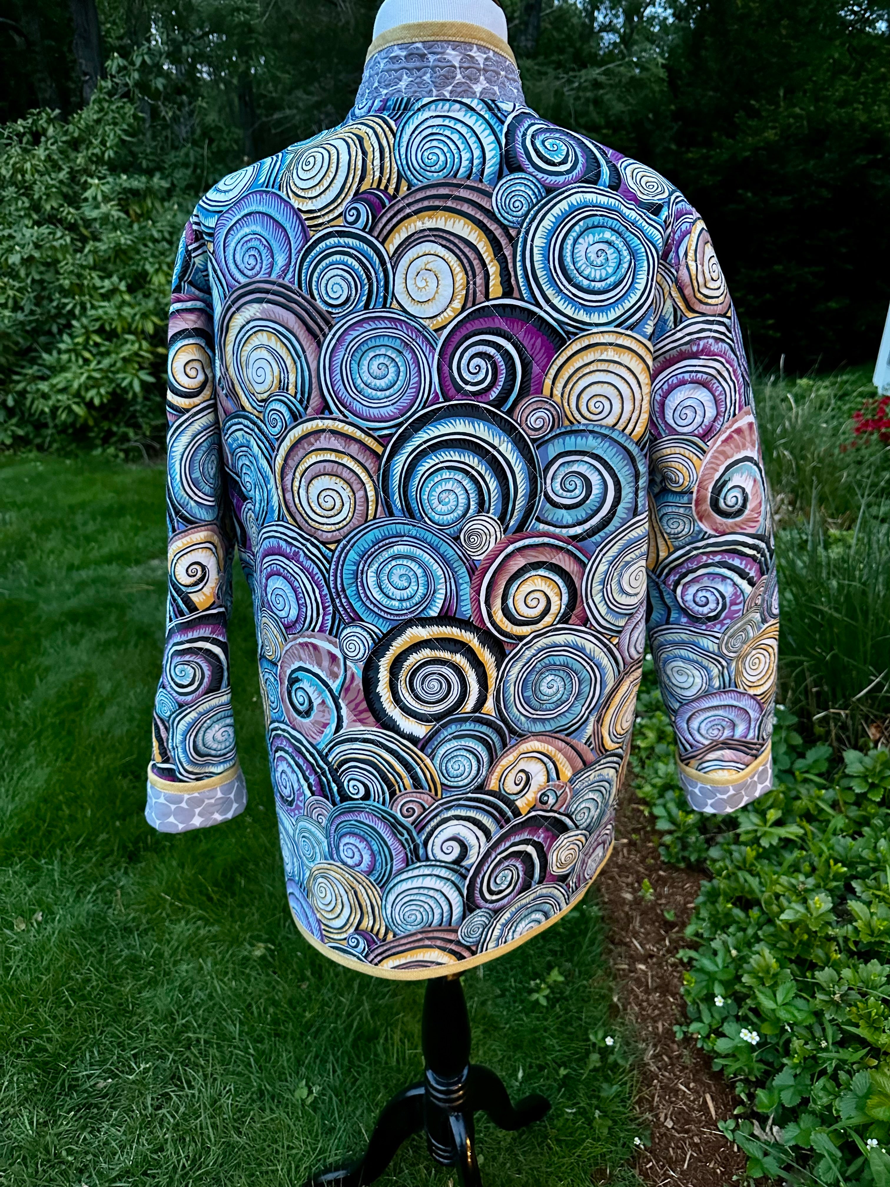 Kaffe Fassett quilted coat back view showing diagonal quilting and handmade sandy-gold binding, women's wearable art coat