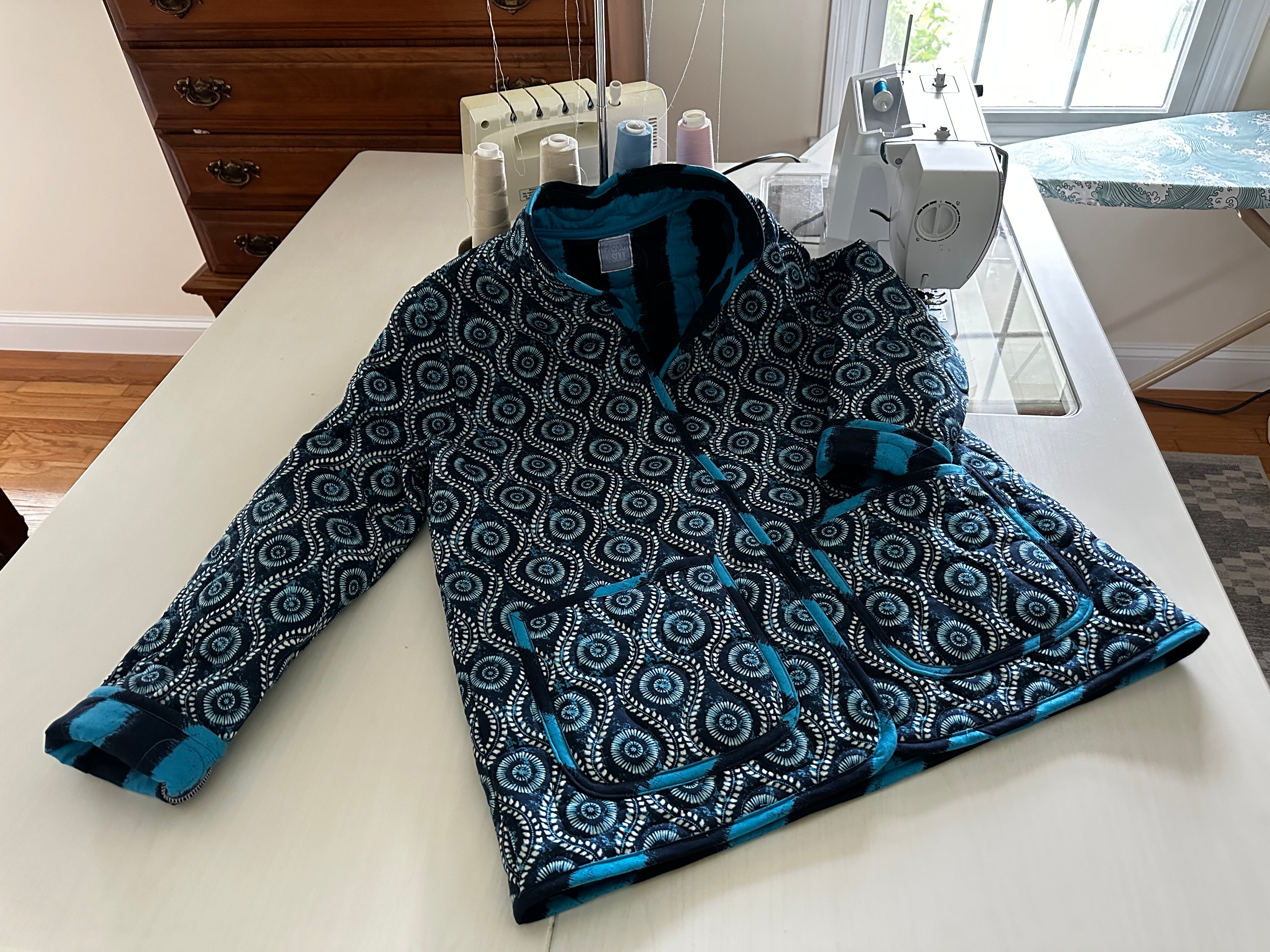 Handmade coastal blue quilted jacket laid flat, full length view, Fabric & Soul