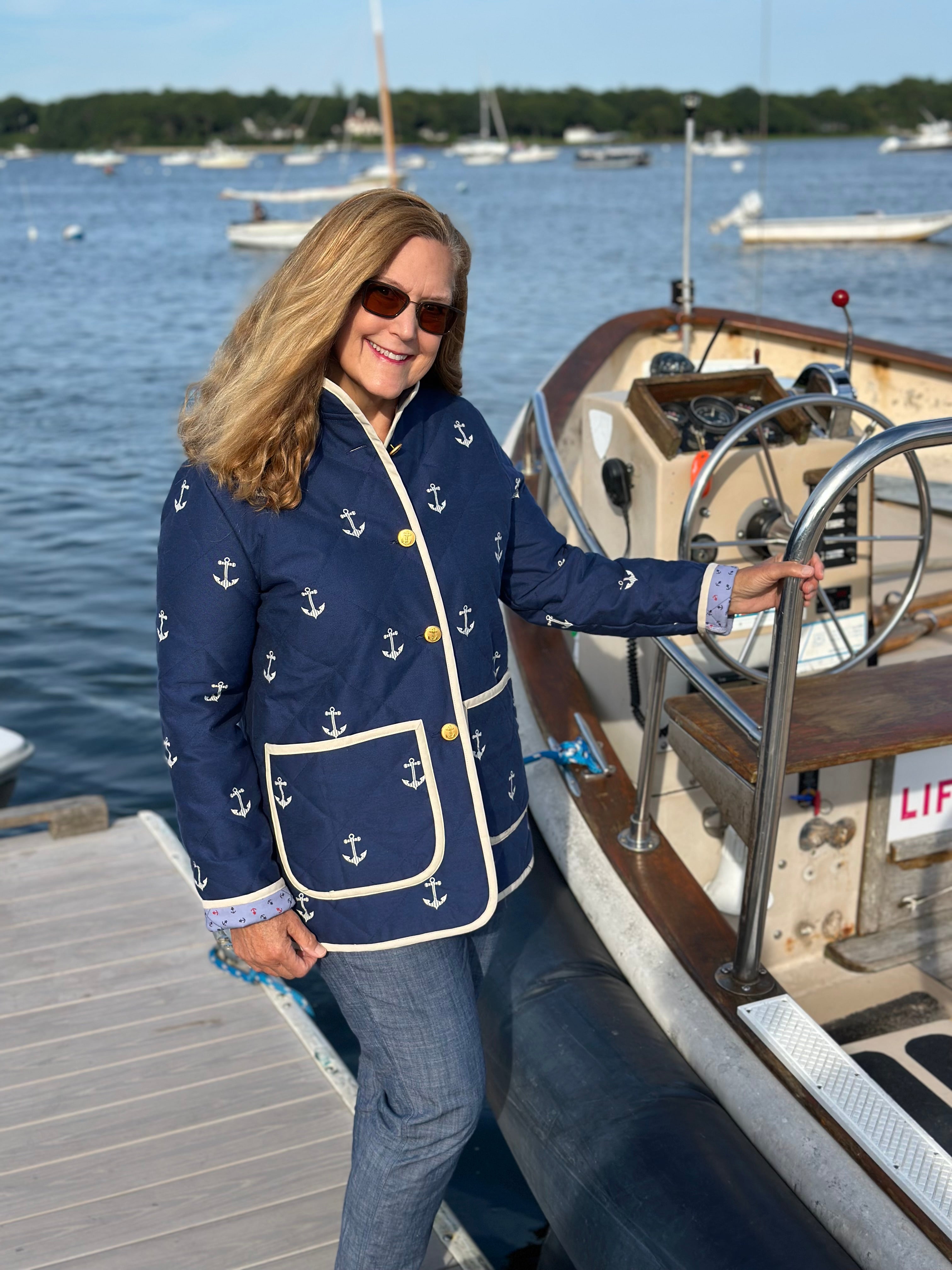 Harbor Heritage Quilted Coat front view showing gold buttons getting into a boat. Handmade by Fabric & Soul in Cotuit, Cape Cod.