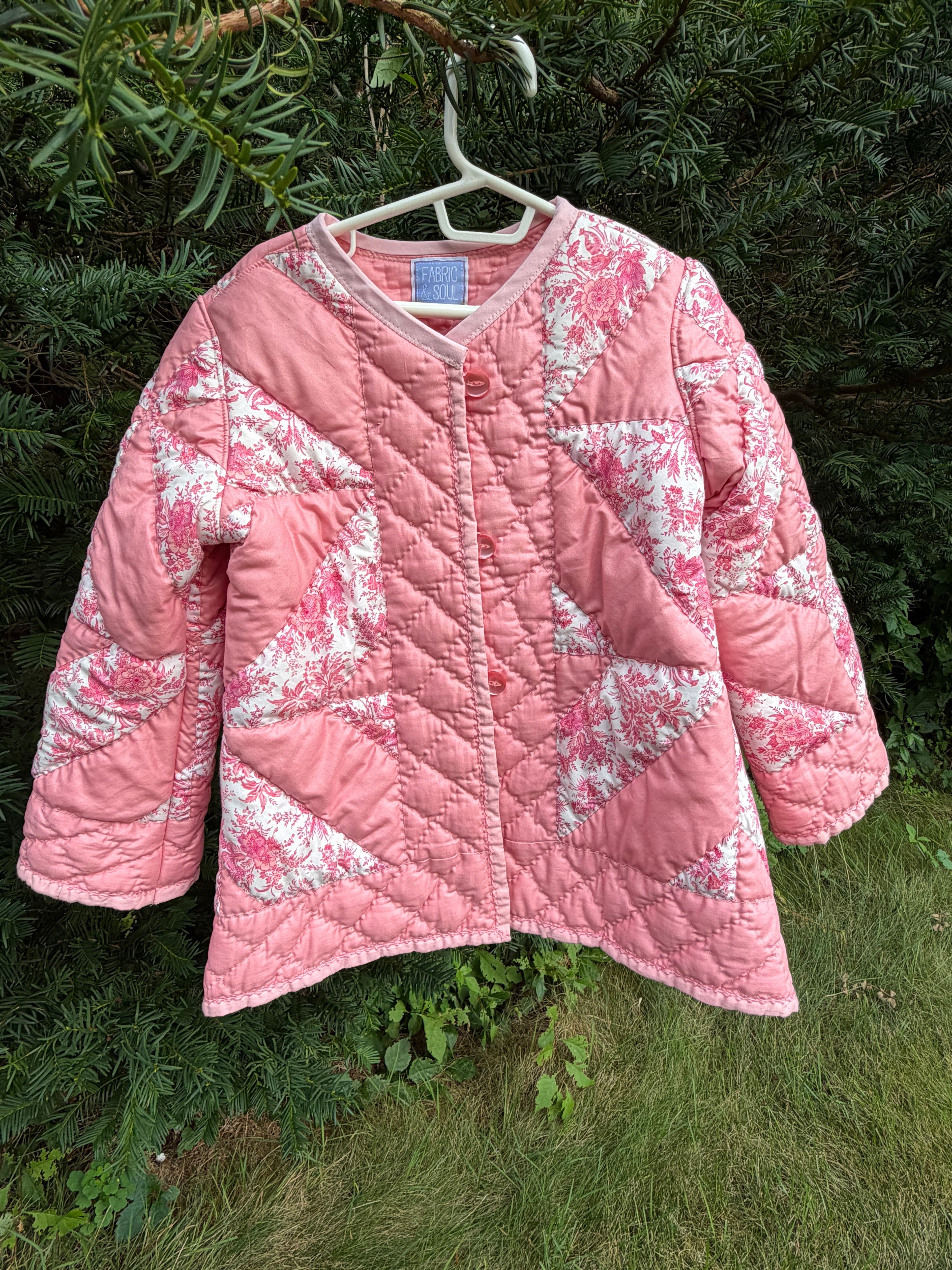 The Chatham Quilt daughter's coat — second front view showing Fabric & Soul label and button detail. Upcycled vintage estate sale quilt, children's size 6/7.