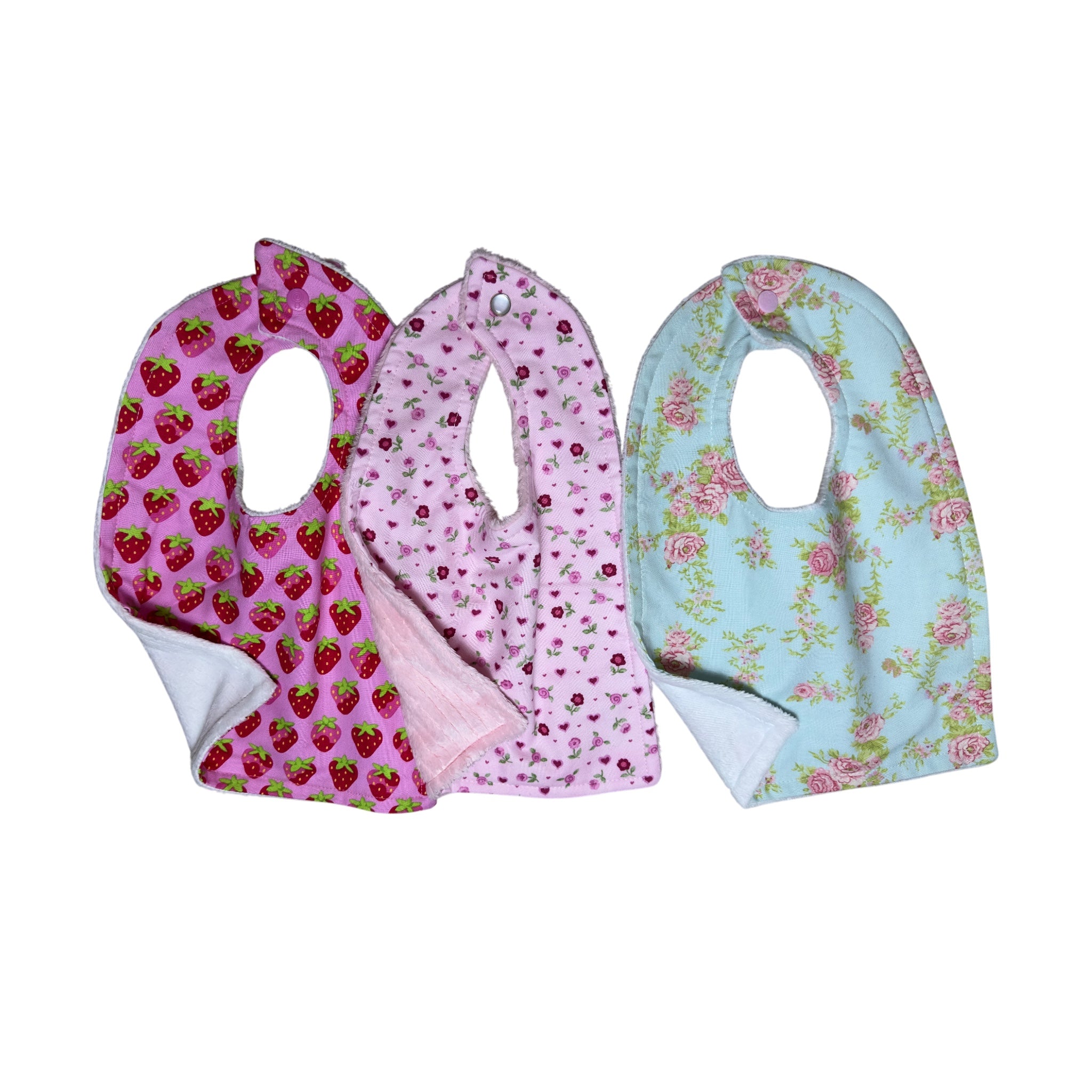 Handmade baby bib set of three with strawberry print, pink floral, and heirloom rose patterns on quilting cotton with soft backing