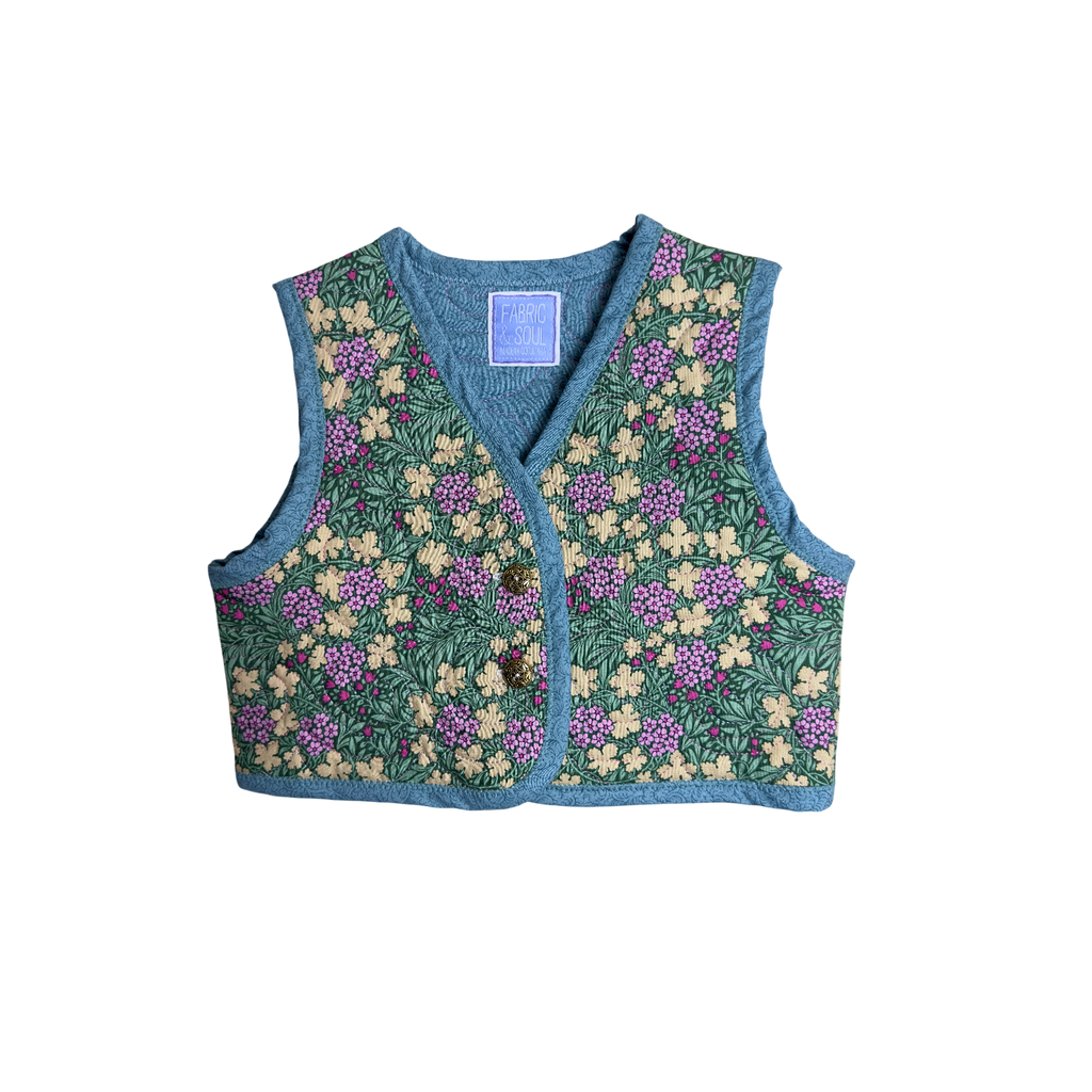 Front view of vest with gold colored buttons 