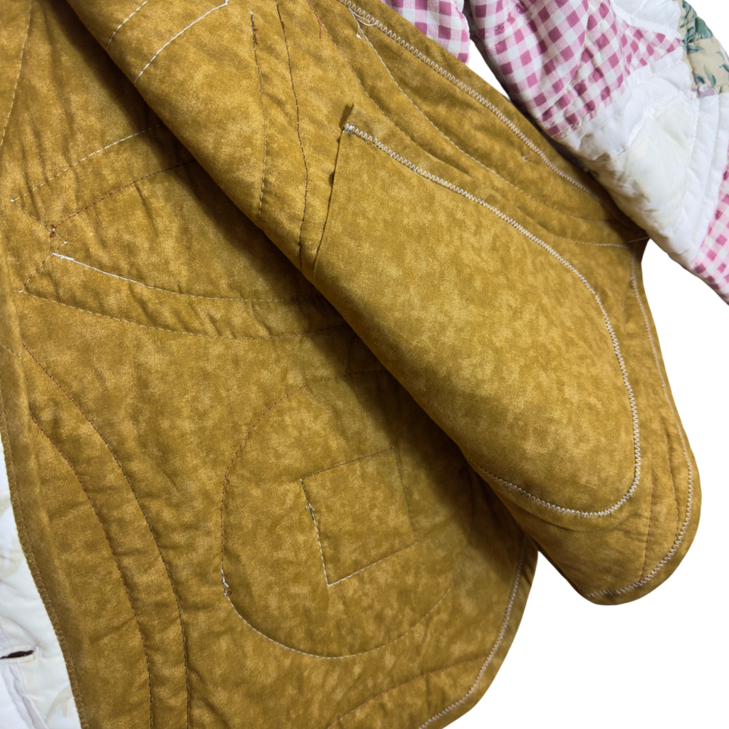 Close-up of a quilted brown fabric inside with visible stitching around inside pocket