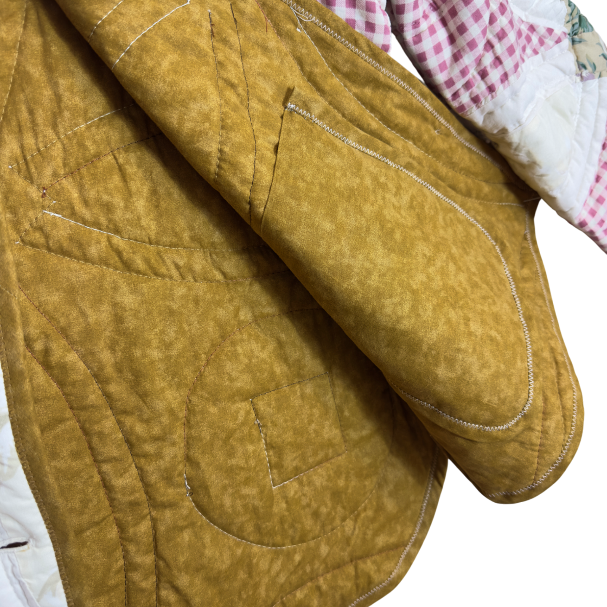 Close-up of a quilted brown fabric inside with visible stitching around inside pocket