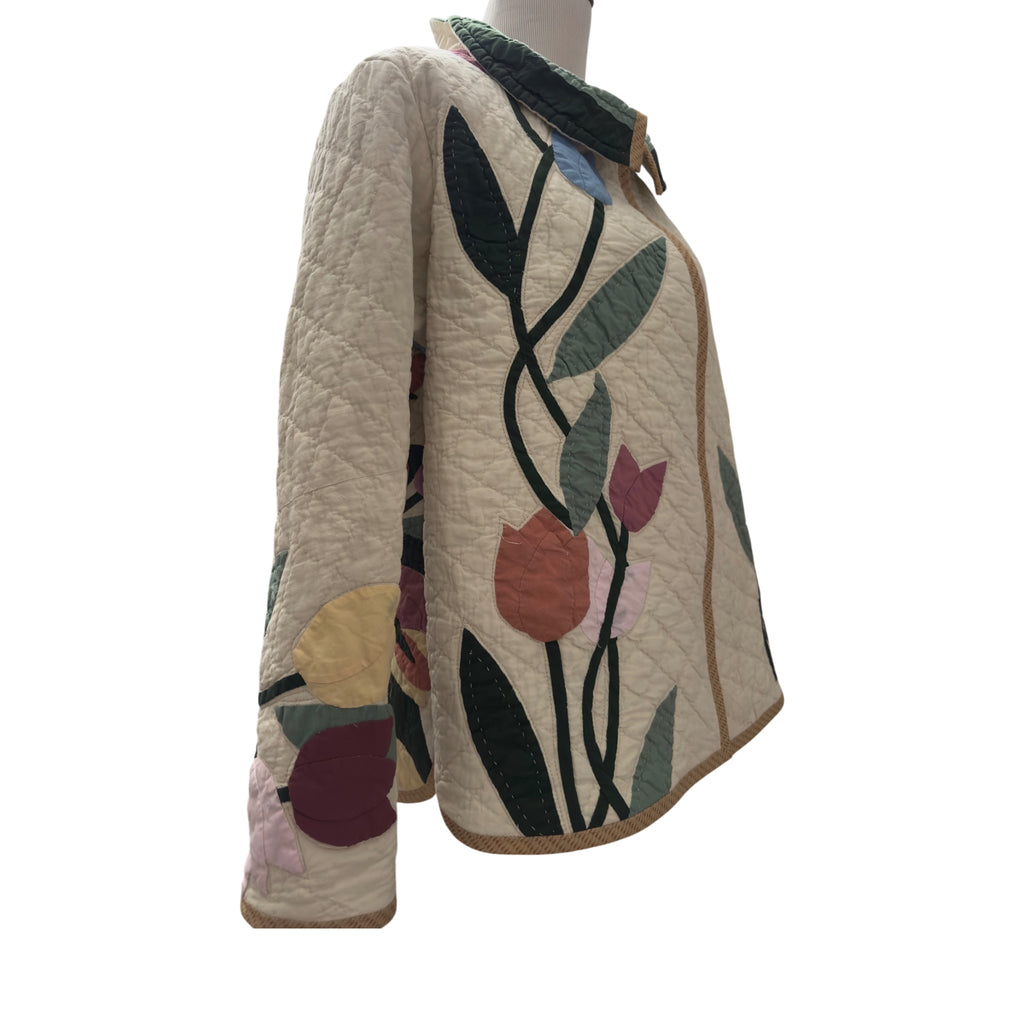 Quilted jacket with floral patterns showing right side appliqué on front and sleeve with binding handmade by Fabric & Soul.